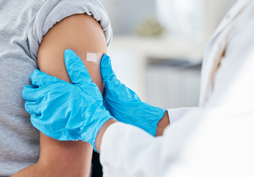 médico colocando um curativo no braça de uma menina